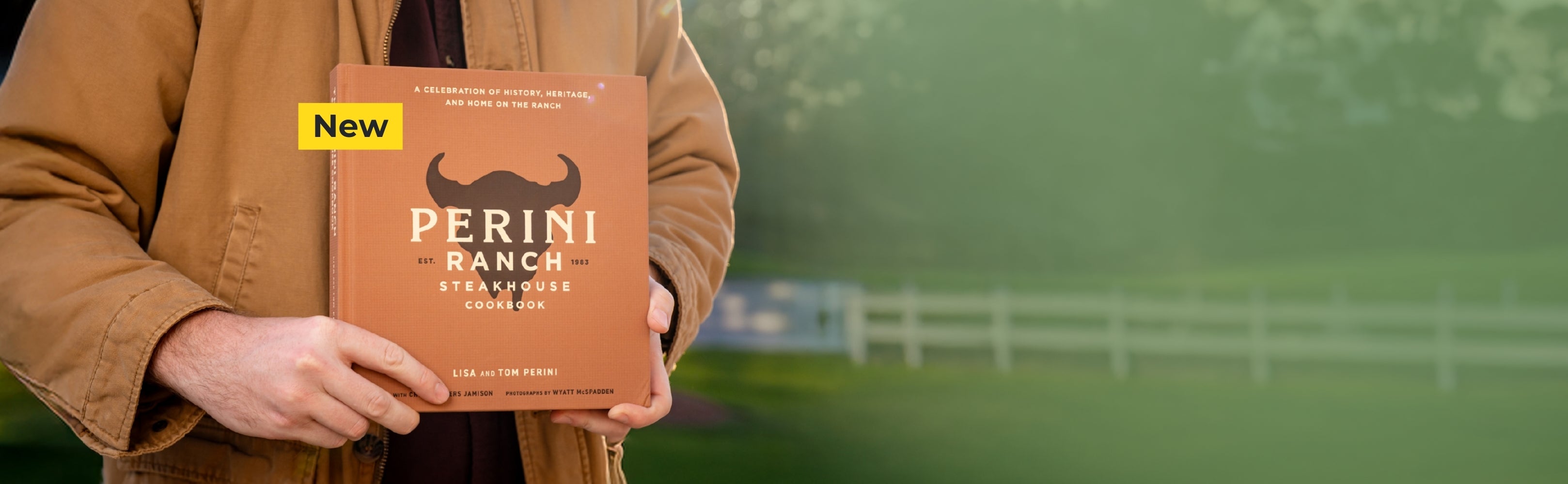 Person holding a Perini Ranch product box with a blurred green background